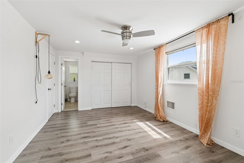 8043 124th Street North Seminole, FL 33772 - Photo 49 of 68 a view of a hallway with wooden floor and a ceiling fan