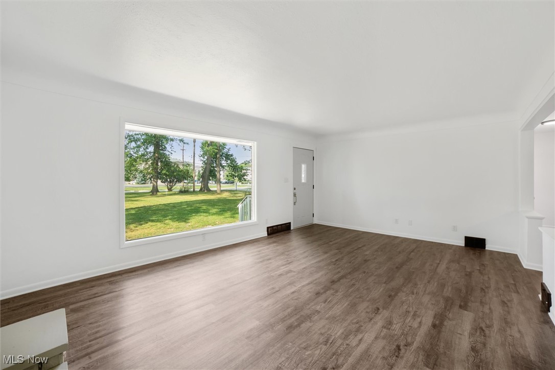 12241 Huffman Road Cleveland, OH 44130 - Photo 7 of 43 Unfurnished living room featuring dark wood-style floors and baseboards