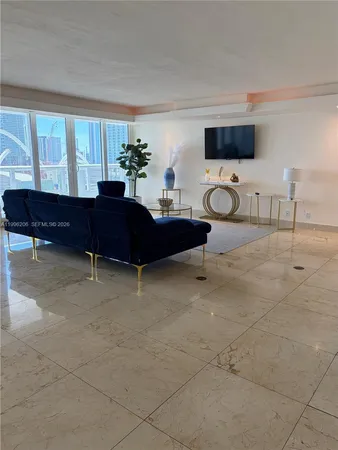 a living room with furniture a flat screen tv and a large window