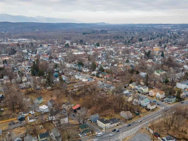 an aerial view of house with yard and mountain view in back