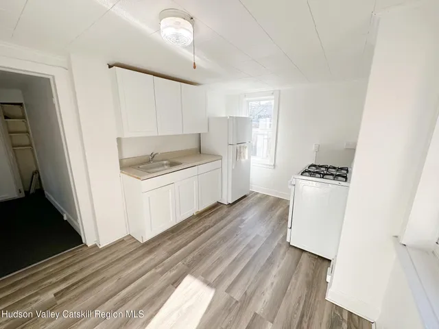 a kitchen with white cabinets and black appliances