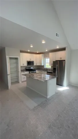 a kitchen with stainless steel appliances granite countertop a stove sink and cabinets