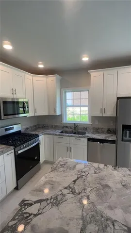 a view of an empty room with a window and fireplace