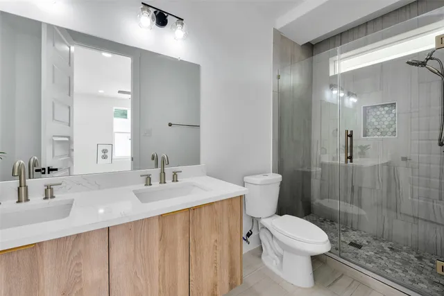 a bathroom with a sink a toilet and shower