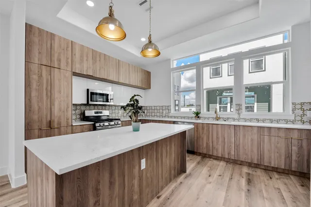 a kitchen with stainless steel appliances granite countertop cabinets a sink a stove a dining table and chairs