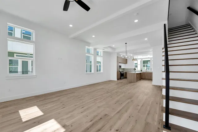 a view of an empty room with window and wooden floor