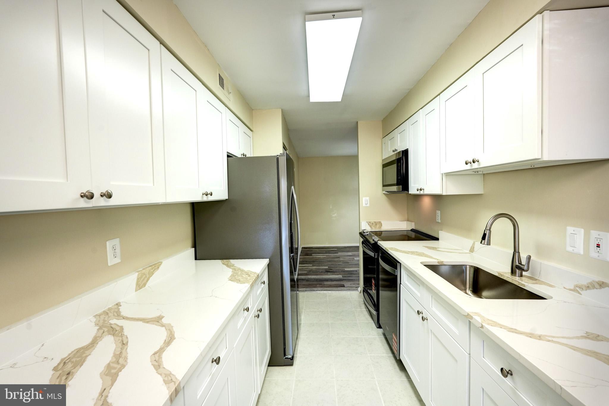 415 Christopher Avenue, Unit 11 Gaithersburg, MD 20879 - Photo 11 of 36 a kitchen with stainless steel appliances a sink a stove and a refrigerator