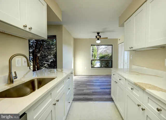a kitchen with granite countertop a sink stainless steel appliances and cabinets