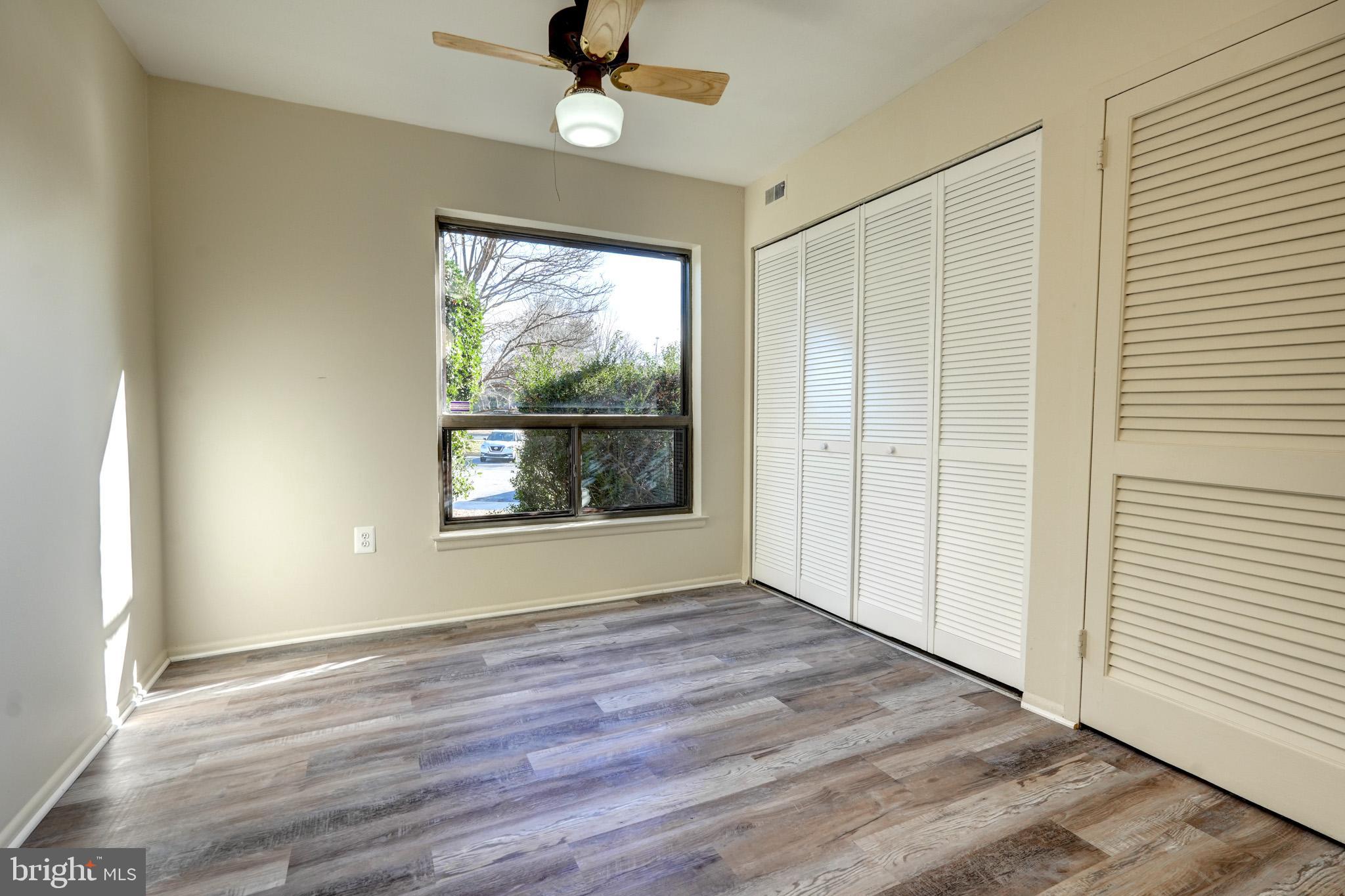 415 Christopher Avenue, Unit 11 Gaithersburg, MD 20879 - Photo 19 of 36 an empty room with wooden floor fan and windows