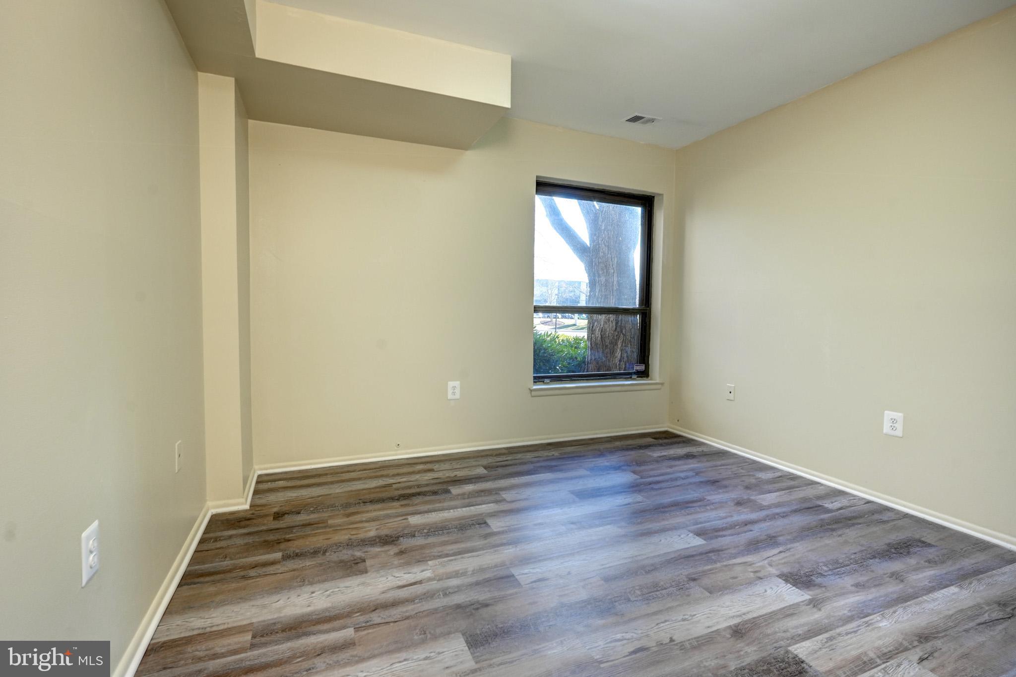 415 Christopher Avenue, Unit 11 Gaithersburg, MD 20879 - Photo 21 of 36 an empty room with wooden floor and windows