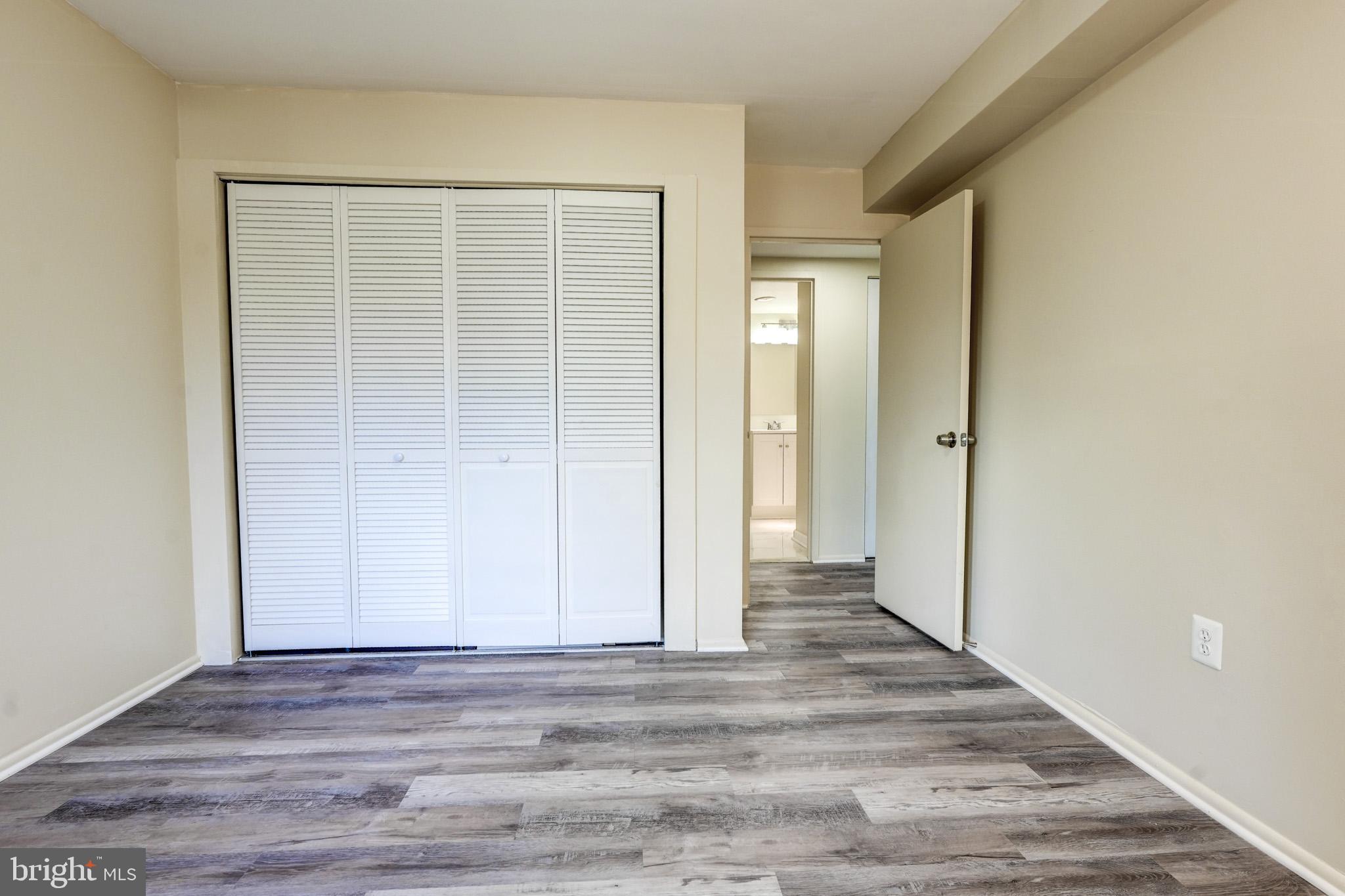 415 Christopher Avenue, Unit 11 Gaithersburg, MD 20879 - Photo 22 of 36 a view of a room with wooden floor and a bathroom
