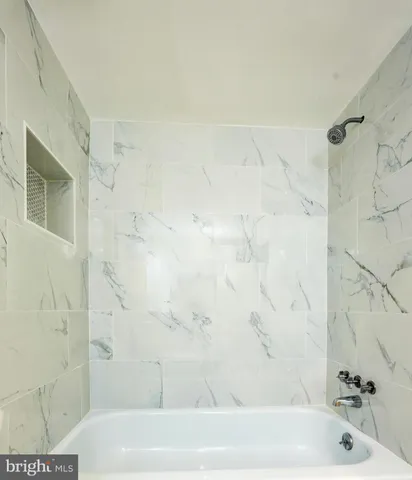 a bathroom with a toilet a sink a mirror a bathtub and vanity