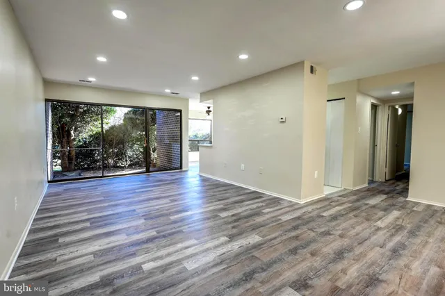 an empty room with wooden floor and entrance