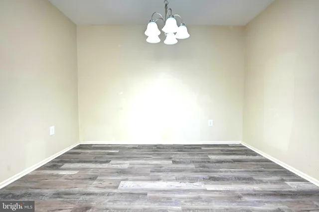 a view of an empty room with a chandelier fan
