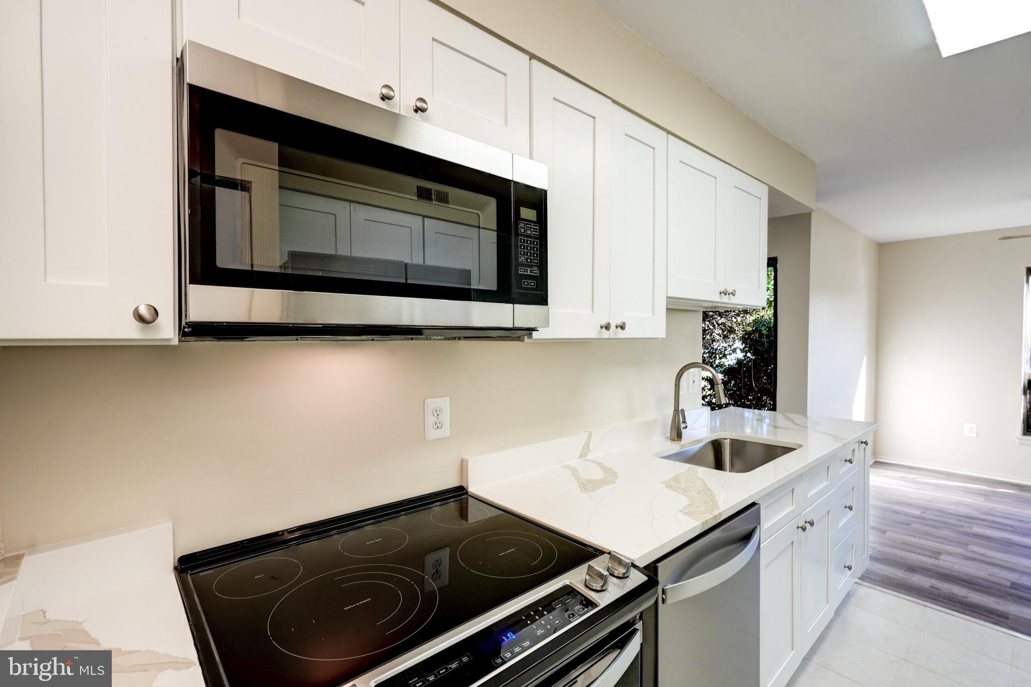 415 Christopher Avenue, Unit 11 Gaithersburg, MD 20879 - Photo 10 of 36 a kitchen with a sink cabinets and microwave