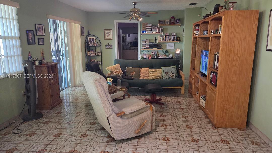 11933 Southwest 196th Terrace Miami, FL 33177 - Photo 11 of 29 a living room with furniture and a baby crib