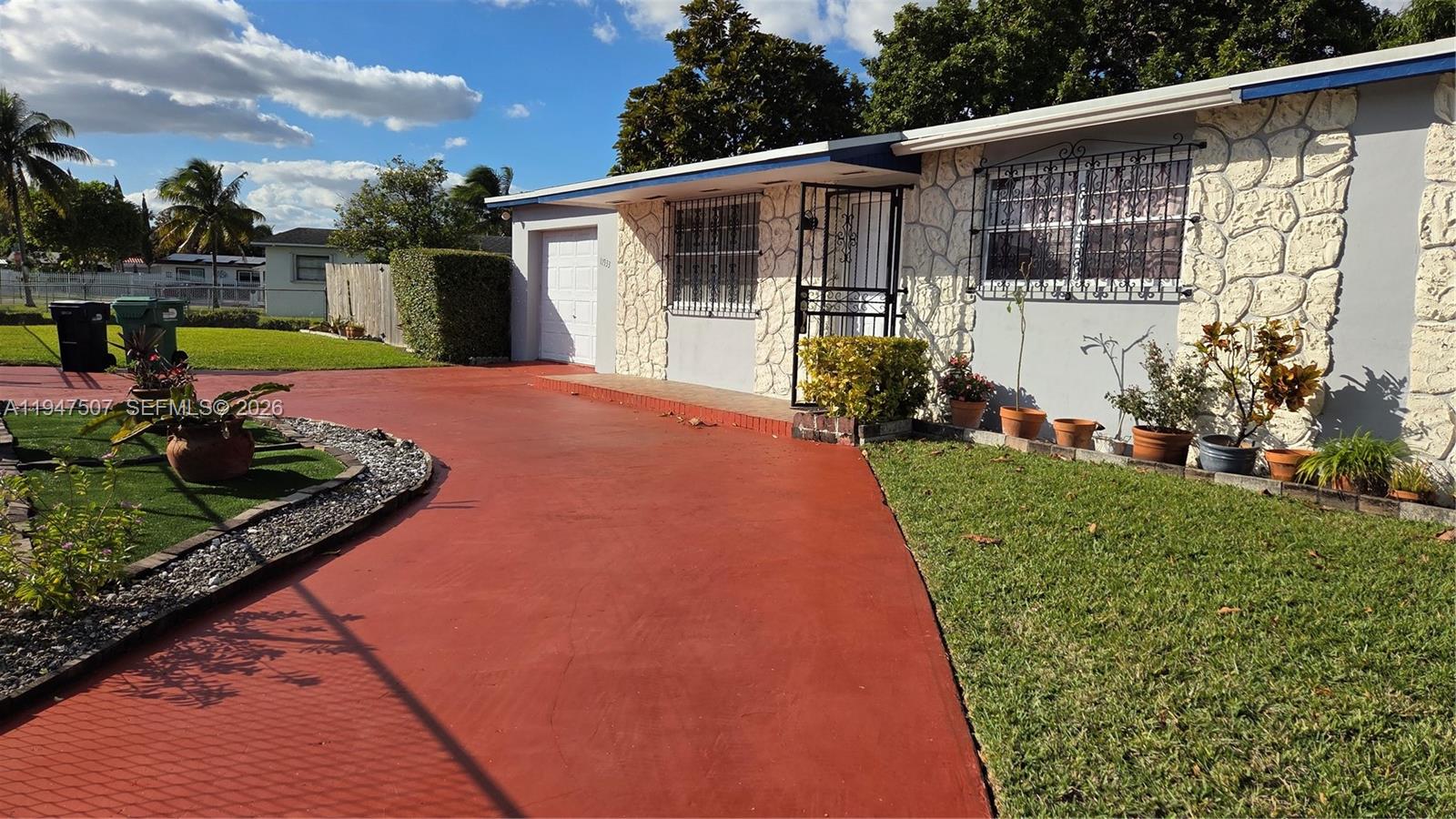 11933 Southwest 196th Terrace Miami, FL 33177 - Photo 2 of 29 a front view of a house with garden