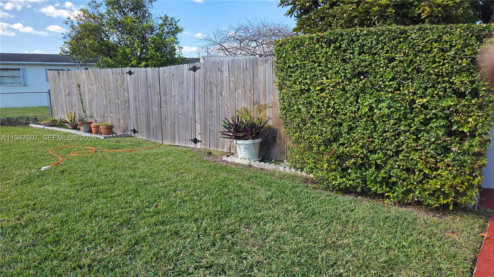 11933 Southwest 196th Terrace Miami, FL 33177 - Photo 6 of 29 a view of a garden with wooden fence