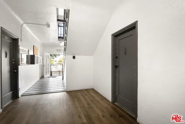 a view of a hallway with wooden floor and a living room