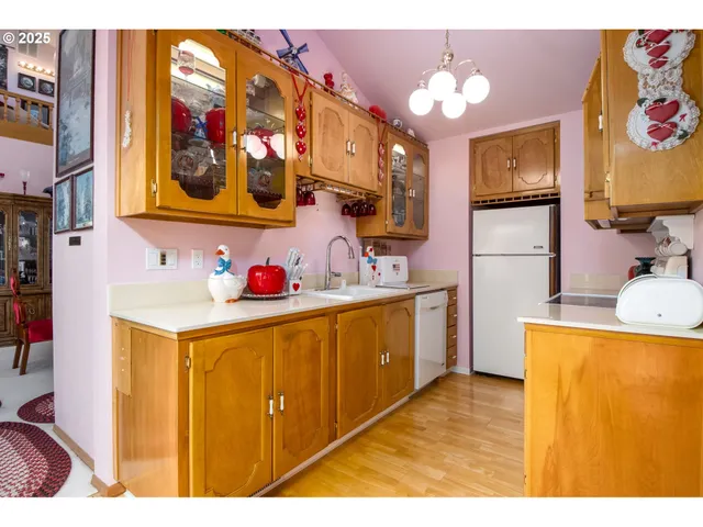 a kitchen that has a lot of cabinets and wooden floor