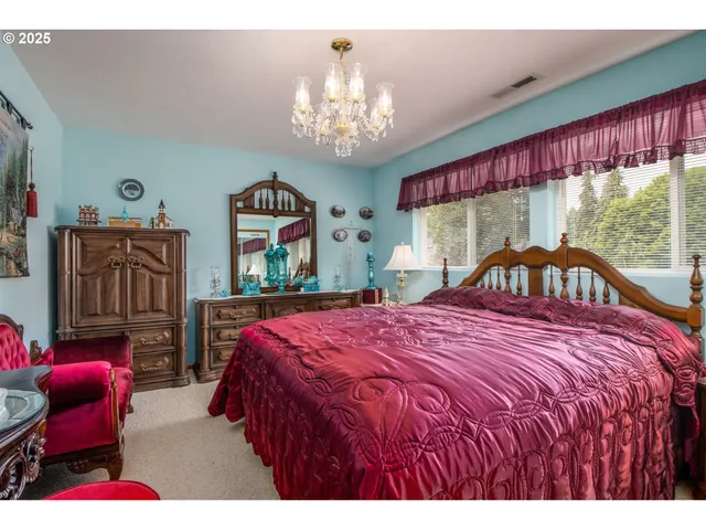 a bedroom with a bed mirror and a window