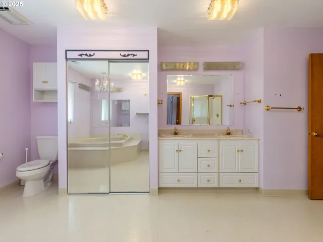 a bathroom with a granite countertop sink mirror and a toilet