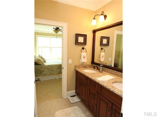6828 Mactavish Way Raleigh, NC 27613 - Photo 18 of 25 a bathroom with a granite countertop sink and a mirror