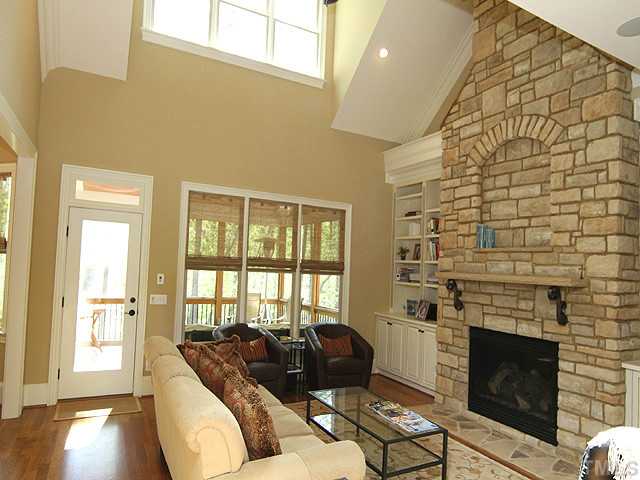 6828 Mactavish Way Raleigh, NC 27613 - Photo 5 of 25 a living room with furniture a fireplace and a floor to ceiling window