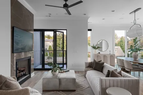a living room with furniture a fireplace and a floor to ceiling window
