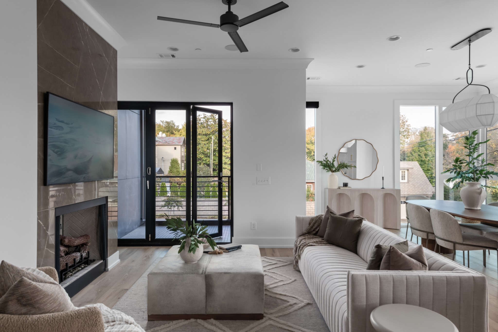 a living room with furniture a fireplace and a floor to ceiling window