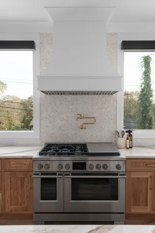 a stove top oven sitting inside of a kitchen
