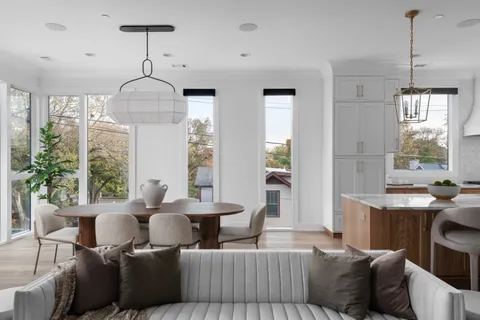 a living room with furniture chandelier and a window