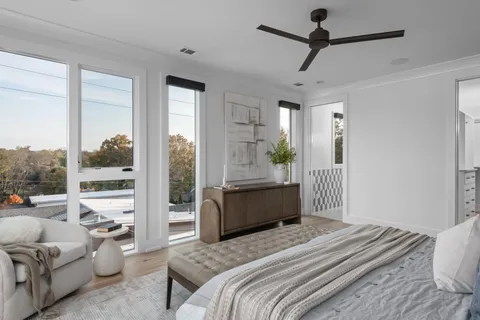 a bedroom with a bed couch and large window