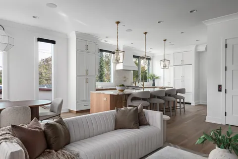 a living room with furniture kitchen area and a window