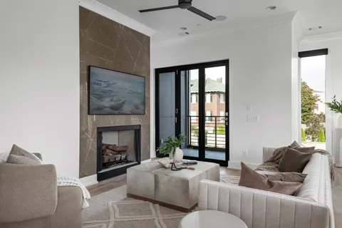 a living room with furniture a fireplace and a large window
