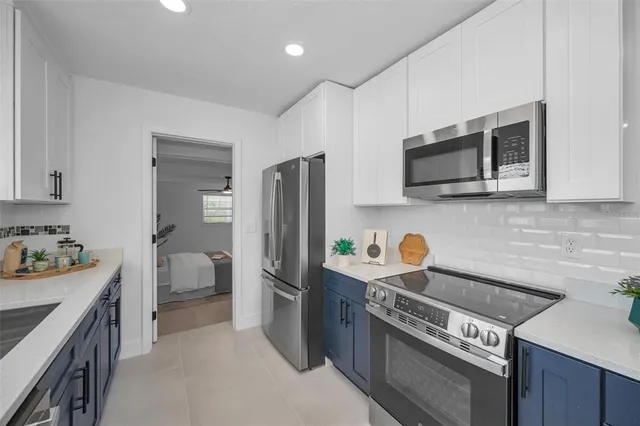 a large kitchen with stainless steel appliances granite countertop a sink and cabinets