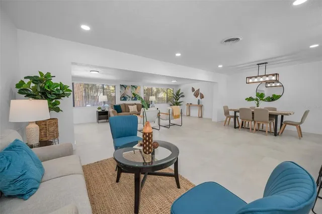 a view of a dining room and livingroom with furniture wooden floor a chandelier