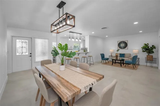 a bedroom with a large bed a chandelier and a potted plant