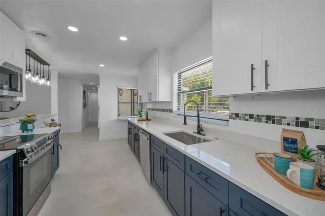 a kitchen with stainless steel appliances granite countertop a sink stove and microwave