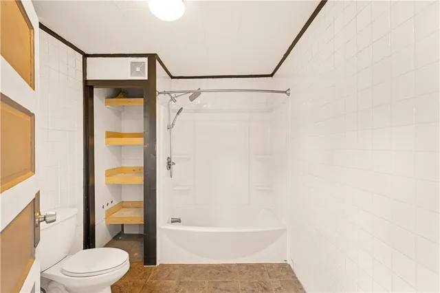 a bathroom with a toilet and a shower