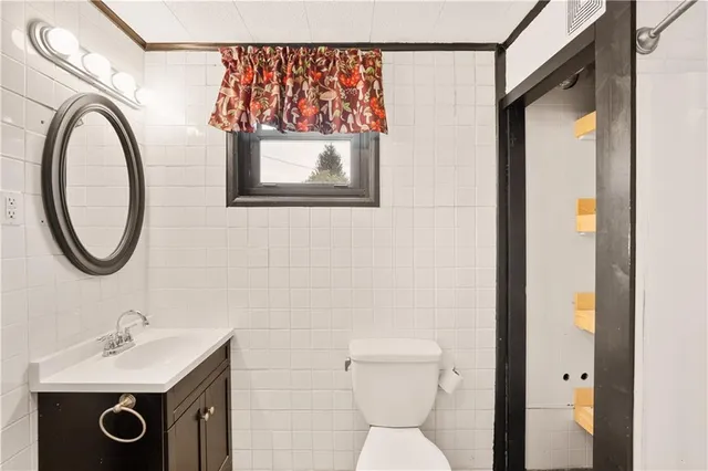 a bathroom with a toilet a sink and a mirror