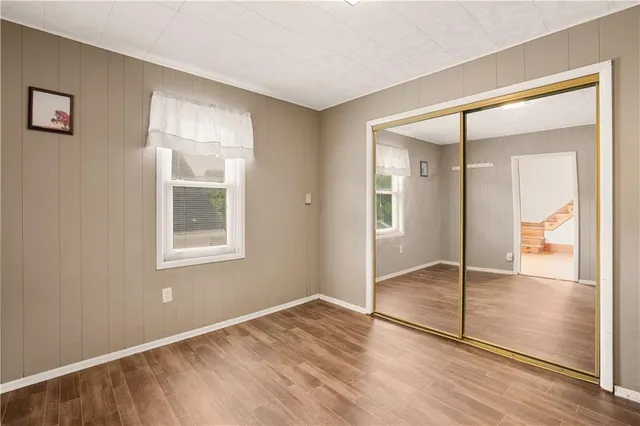 an empty room with wooden floor and a window