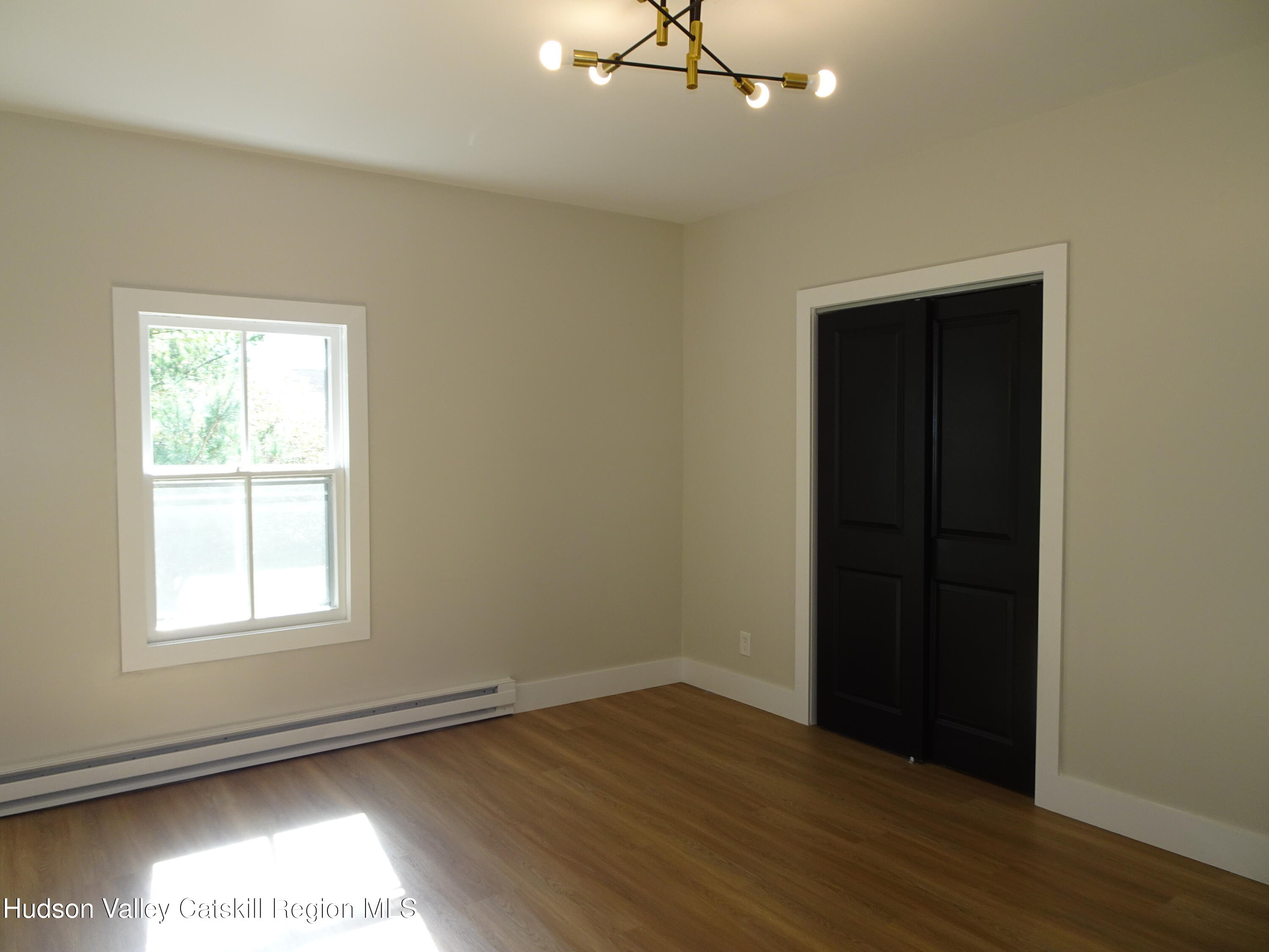 167 Highway 23, Unit 4C Claverack, NY 12513 - Photo 17 of 25 an empty room with wooden floor closet and windows