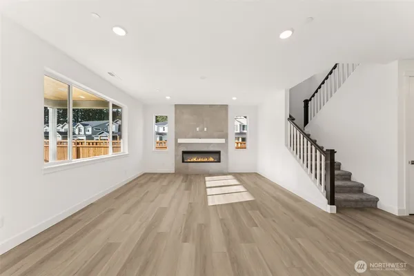 a view of an empty room with a window and fire place