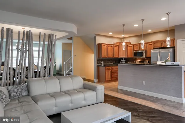 a living room with stainless steel appliances kitchen island granite countertop furniture and a view of kitchen