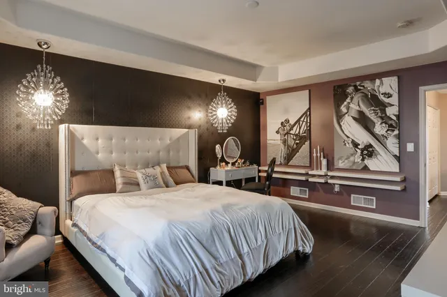 a bed sitting in a bedroom and chandelier