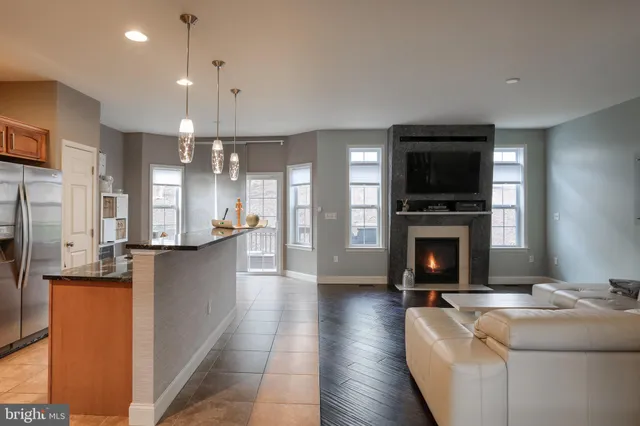 a living room with furniture a fireplace and a open kitchen view