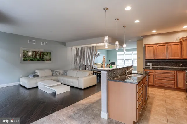 a kitchen with stainless steel appliances kitchen island granite countertop a stove and a sink