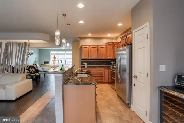 a kitchen with refrigerator a stove and a sink with couches