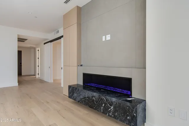 a view of an empty room with wooden floor and city view